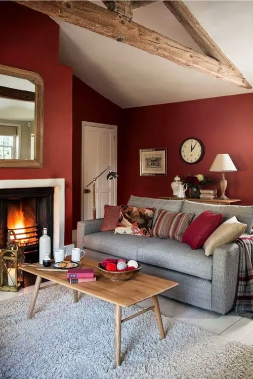 Cozy comfy small living room ideas in warm colors - love this red / burgundy living room wall paint color with the gray couch - looks great!
