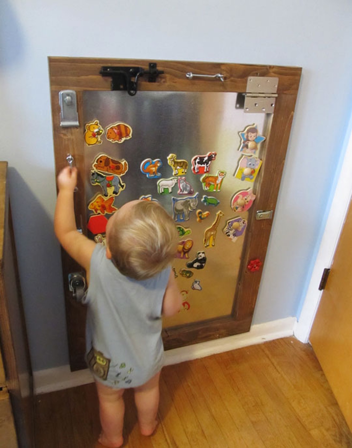 MAGNETIC busy board idea for toddlers.  Not only does this sensory board have latches it also has a magnetic area.  Brilliant!