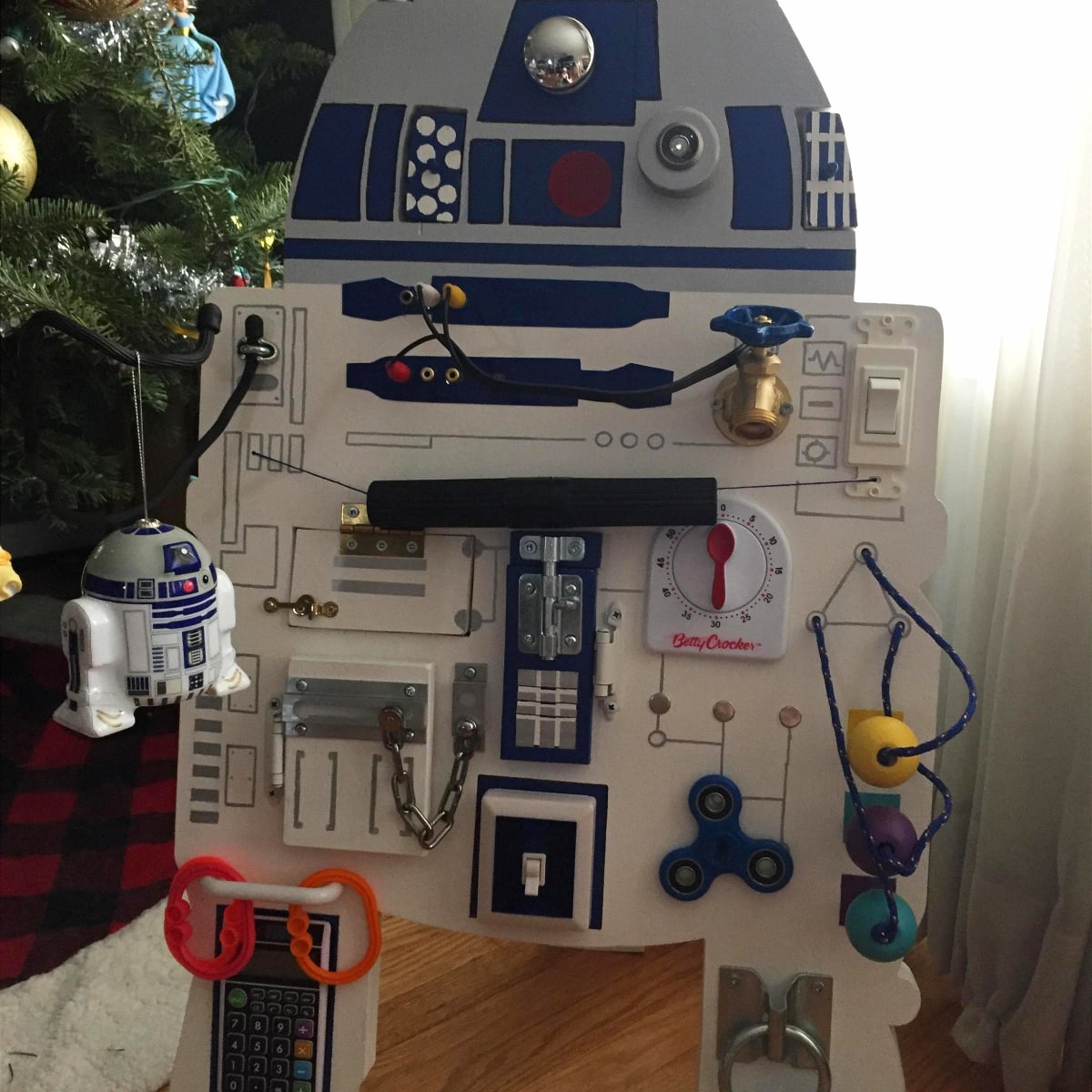 Toddler busy board idea to make - it's a Star Wars busy board! This R2-D2 sensory activity board is perfect for keeping your toddler busy while he / she fisgets with the gadgets and latches!