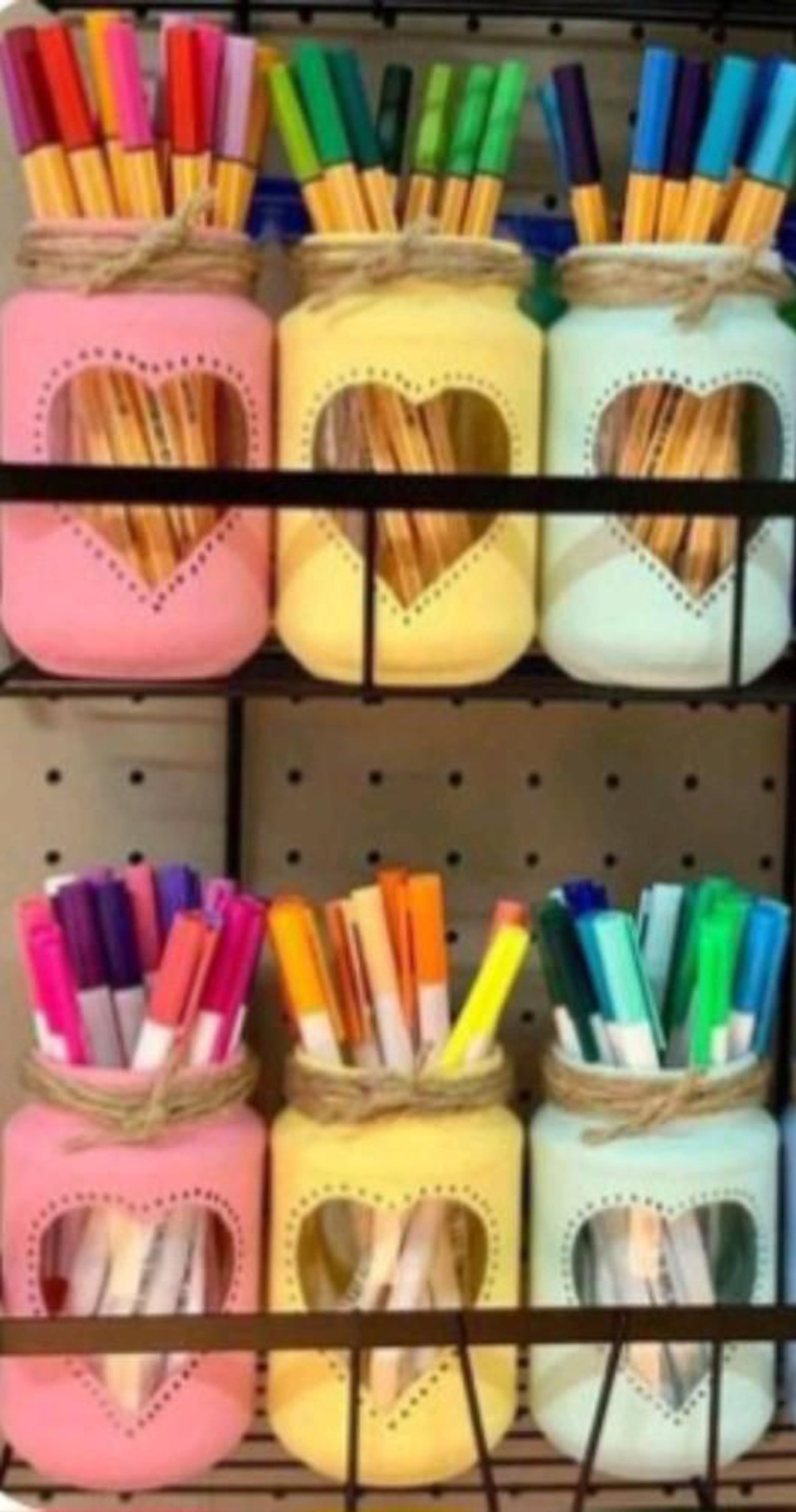 colorful painted mason jars on peg board craft room wall for organization and storage